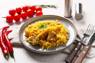 Plate of tasty pilaf with chili peppers and cherry tomatoes on white background, closeup
