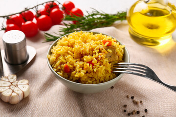 Bowl with tasty pilaf and ingredients on table, closeup