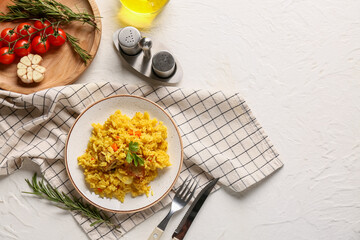 Plate of tasty pilaf with rosemary, garlic and cherry tomatoes on white background