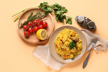 Plate with tasty pilaf and ingredients on orange background