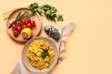 Plate with tasty pilaf and ingredients on orange background