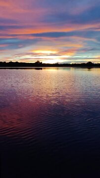 Beautiful sunrise view from yacht cruising Amazon Jungle River. Amazing sunset as seen from a boat side in the golden hours. Pink and blue. Forest Silhouette. Anavilhanas, Amazonia, Manaus, Brazil.