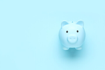 Blue piggy bank on color background