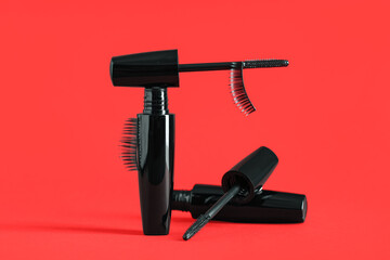 Black mascaras with false eyelashes on red background