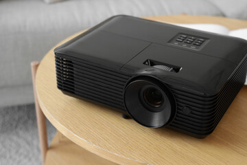 Modern projector on wooden table in room, closeup