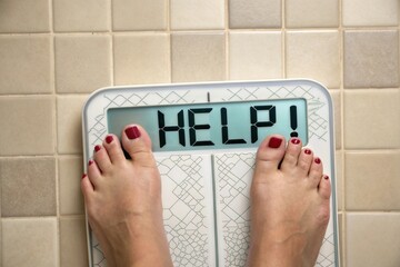 A womans feet on a bathroom scale displaying HELP! in a close-up shot, conveying the emotional weight of a weight-loss struggle - generated by ai
