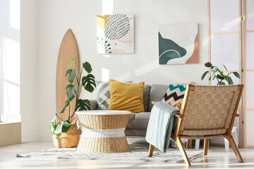 Interior of living room with surfboard, sofa and armchair