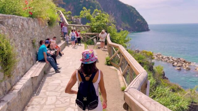 Young Woman Walking Through Picturesque Streets of Cinque Terre, Italy, Rear View in Colorful Mediterranean Village
