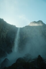 Scenery with granite cliffs, greenery, cascading waterfalls blue skies at Yosemite National Park in California’s Sierra Nevada mountains