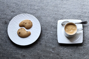 White ceramic coffee cup with hot morning coffee and biscuits on a rustic wooden table. A cozy breakfast scene filled with warmth, aroma, and the charm of a simple daily ritual.