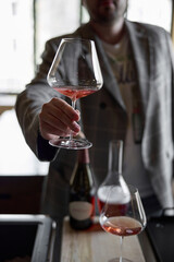 Champagne tasting in restaurant, A man holds in his hand a beautiful elegant glass with rose sparkling wine
