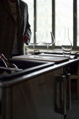 Clean wine glasses and decanter are on the table of a special wine cabinet, stylish table setting,...