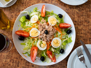 Delicious salad with canned tuna, boiled eggs and fresh tomatoes