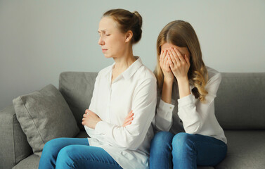 Upset offended caucasian two women, mature mother or sister and adult daughter together at home
