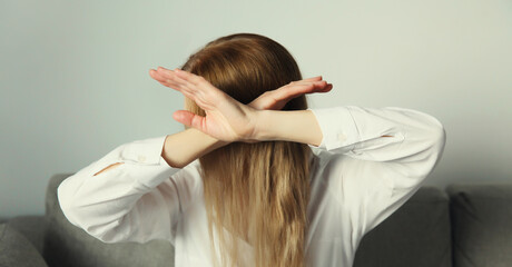 Fototapeta premium Woman shows stop, no or enough sign with palm of hand, refusal gesture, domestic violence