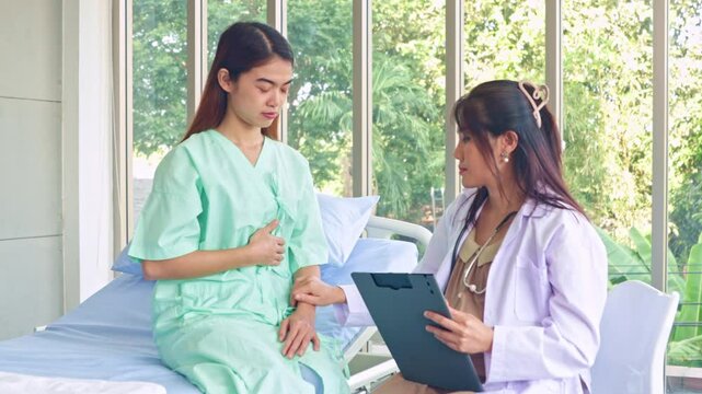 Pregnant female doctor working examining female patient who is sick and being treated in the hospital taking information from the patient make preliminary diagnosis assess the patient's symptoms.