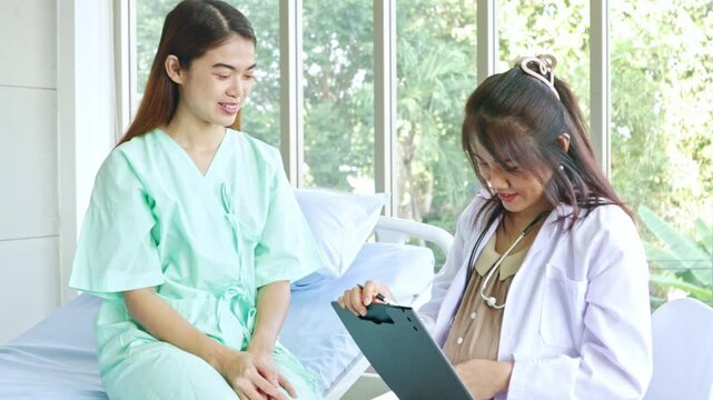 Pregnant female doctor working examining female patient who is sick and being treated in the hospital taking information from the patient make preliminary diagnosis assess the patient's symptoms.