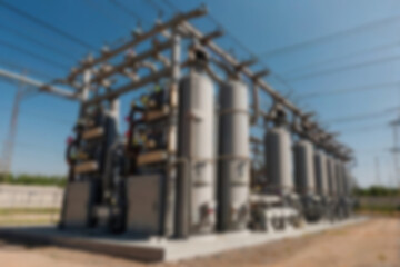 Obraz premium blurry electrical substation, large transformer as voltage regulator, there are many high voltage electrical panels