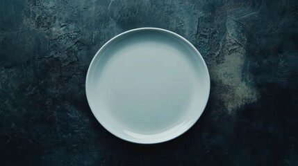 Empty white plate on dark textured surface. (2)