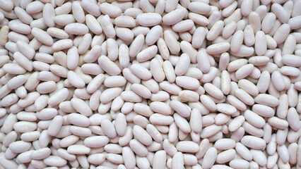 Close-up image of a large pile of white kidney beans, also known as cannellini beans. 