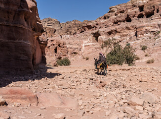 Bedouin man riding a donkey on trail to Ad Deir or the Monastery from Petra which is 1.6km and 800 steps