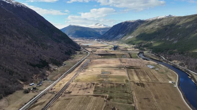 Valley view of Selsmyrin near Otta, with fields, river, and snow-capped peaks beyond