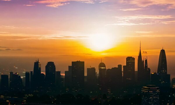 Time lapse of the sun sets behind the skyline of the city at sunset light