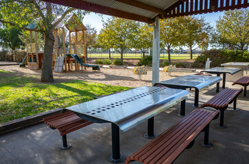 Covered picnic shelter with barbecue facilities, dining tables,and seating benches in an Australian...