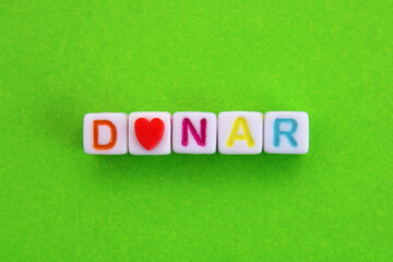 Cubes with the word donate with a heart symbol, text in Spanish
