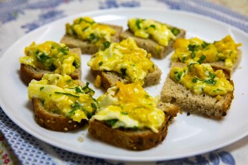 Scrambled eggs with parsley served on sourdough artisan bread