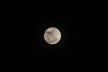 Super full moon in the night sky with clouds, 