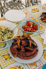 Delicious grilled sausages served alongside fresh salads and potatoes at a sunny outdoor dining area in summer