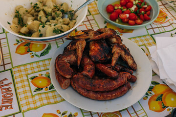 Grilled meats and fresh salad displayed on a colorful table during a summer gathering