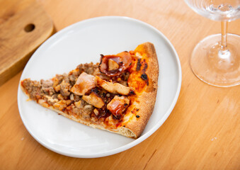 Slice of delicious pizza with minced meat, bacon bits and barbecue sauce