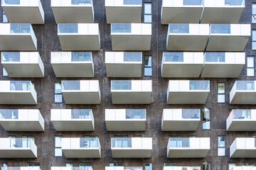 Modern apartment facade with repetitive balconies forming geometric pattern in Copenhagen, residential architecture, ideal for urban housing, real estate design and building structure in Copenhagen, C