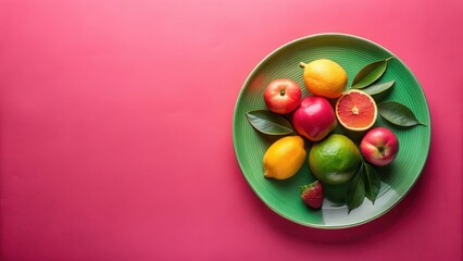 Vibrant assortment of fresh fruit arranged on a green plate against a pink background, showcasing a healthy and delicious composition.