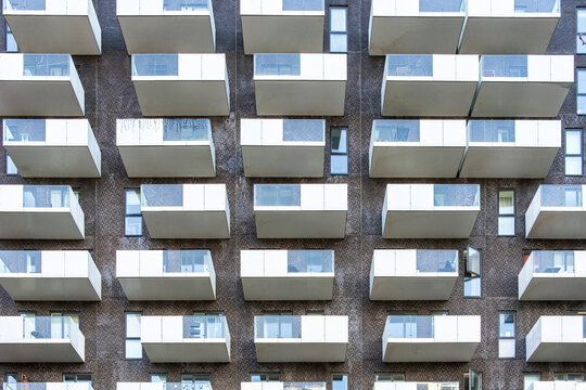 Modern apartment facade with repetitive balconies forming geometric pattern in Copenhagen, residential architecture, ideal for urban housing, real estate design and building structure in Copenhagen, C