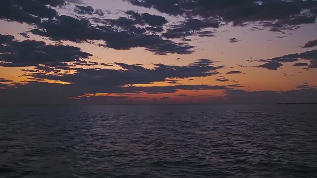 Vibrant sunset over the ocean with dramatic clouds, perfect for romantic or scenic backgrounds
