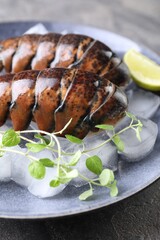 Raw lobster tails with microgreens, lime and ice on table, closeup