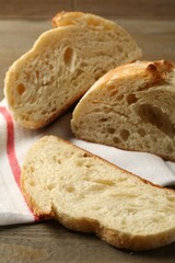 Slices of fresh bread on wooden table, closeup