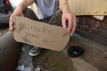 Man with sign Homeless please help outdoors, closeup