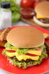 Tasty cheeseburger with lettuce and tomatoes on white table, closeup