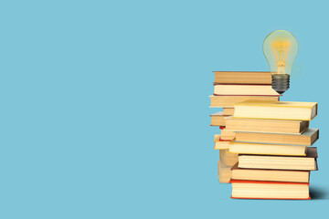 Idea and knowledge. Light bulb in air over stack of books on light blue background, space for text
