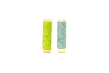 Green spool and Tosca spool of sewing thread isolated on white background 