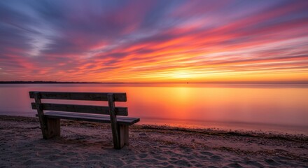 Bench overlooking water reflecting serenity and peace at sunset, beach scenery