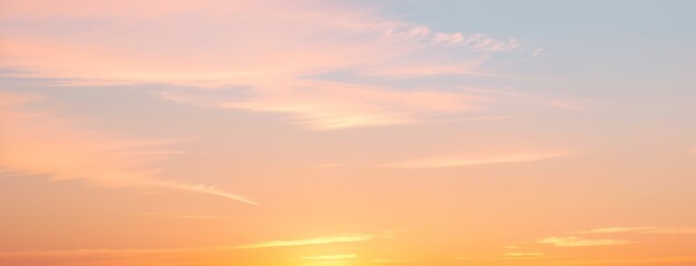 Sky with soft pastel colors orange yellow and blue at sunset or sunrise.