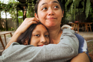 Asian family love and affection between mother and teen daughter, embracing each other tenderly