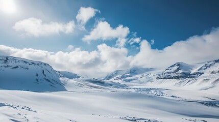 Naklejka premium Snow Capped Mountains Under Blue Sky With Bright Sunlight and Scattered Clouds