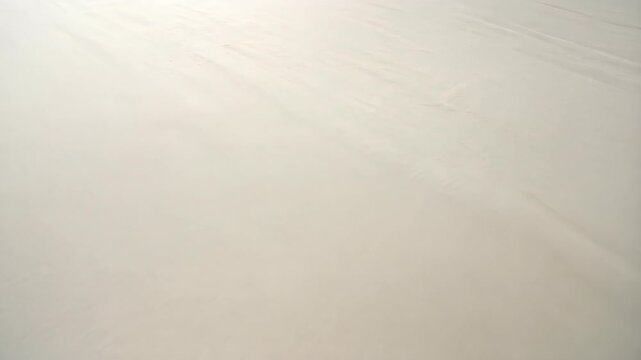 Wrinkled beige linen fabric surface, background texture with soft neutral color and subtle light and shadow play, natural material.