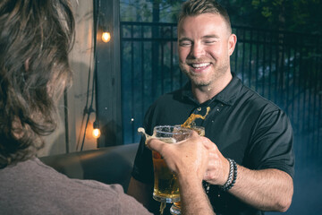 Friends celebrating and cheering with beer pints for National Beer Lover's Day.